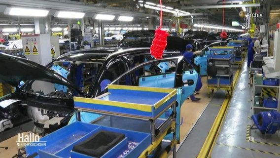 Veduta della linea di una fabbrica di automobili: diversi dipendenti che lavorano su modelli di automobili non finiti. Veduta della linea di una fabbrica di automobili: diversi dipendenti che lavorano su modelli di automobili non finiti. ©Schermata