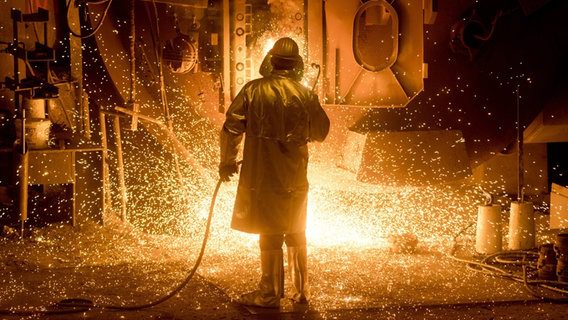 Un dipendente della Salzgitter AG in abbigliamento protettivo lavora su una siviera d'acciaio.  © Picture Alliance / Julian Stratenschulte / dpa Foto: Julian Stratenschulte