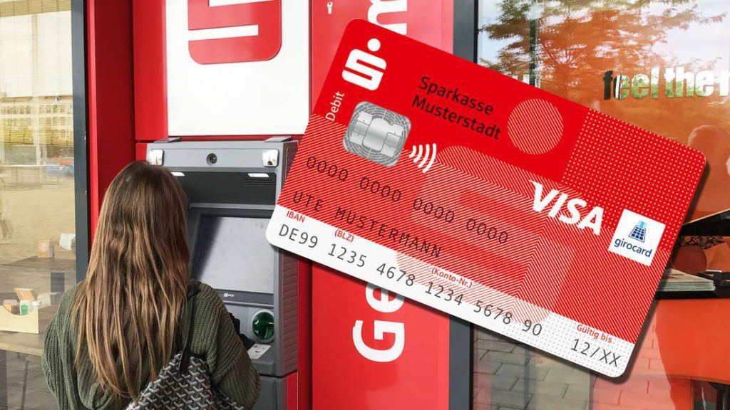 Giovane donna in piedi davanti a un bancomat con una carta di debito Sparkas