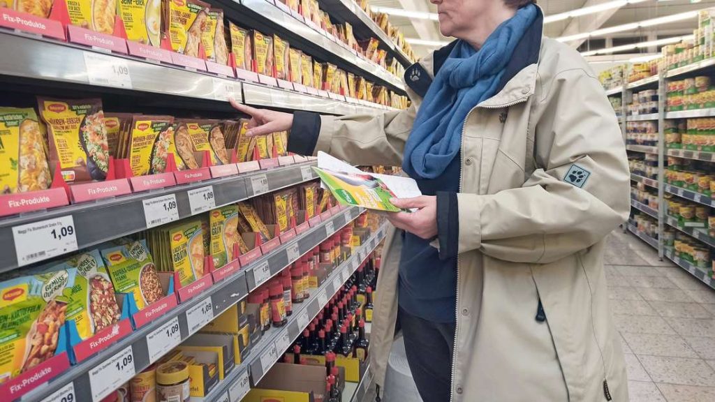 Una donna è in piedi davanti allo scaffale di un Maggi's al supermercato