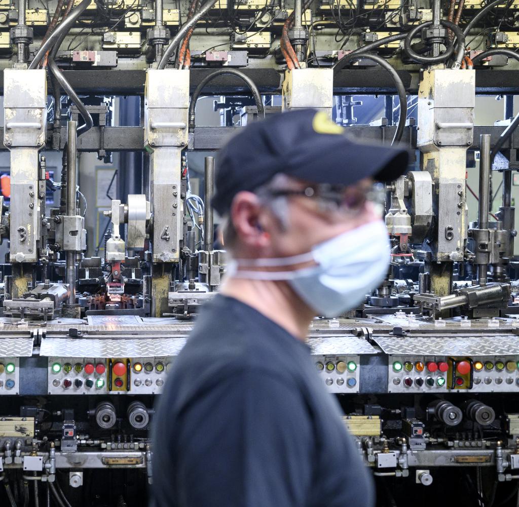 Un dipendente della Heinz-Glas passa davanti a uno stabilimento di produzione di bottiglie