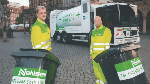 Due uomini che trasportano bidoni della spazzatura si fermano davanti a un camion della spazzatura
